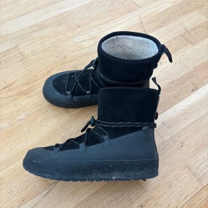 Svarta vinterboots med snörning - Säljer ett par svarta vinterboots med snörning och mjukt foder. Skorna har en robust sula och är perfekta för kalla dagar. De är tillverkade i mocka och syntetmaterial, vilket ger både stil och funktionalitet.