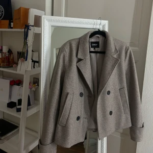 KAPPA - ONLY - Snygg beige kappa från ONLY med dubbelknäppning och klassisk krage. Jackan har en stilren design med två fickor framtill och är perfekt för höst och vår men även varmare vinterdagar. Den har långa ärmar och en rak passform. Jackan är knappt använd och är nästan i nyskick! Säljer eftersom jag har köpt en annan jag trivs i 🤎