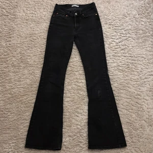 Svarta bootcut jeans från Gina tricot  - Snygga svarta bootcut jeans från Gina tricot. De har en klassisk femficksdesign med knapp och dragkedja framtill. Perfekta för en stilren look.