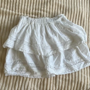 Vit volangkjol med spets från BikBok - Supersöt vit kortkjol från BikBok med volanger och fina spetsdetaljer. Kjolen har resår i midjan och dubbla lager. Perfekt för alla tillfällen!! Endast testad!! Pris går att diskuteras