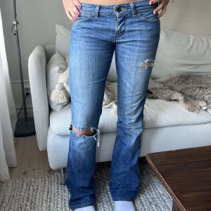 Blåa super lowwaist lowrise lågmidjade bootcut utsvängda jeans med hål slitningar - Se profil för fler jeans💕Midja: ca 37,5💕 Innerben: ca 80 cm💕själv gjort hålen💕pyttelite fläckig längst ned men inget man tänker på alls (se sista bild)