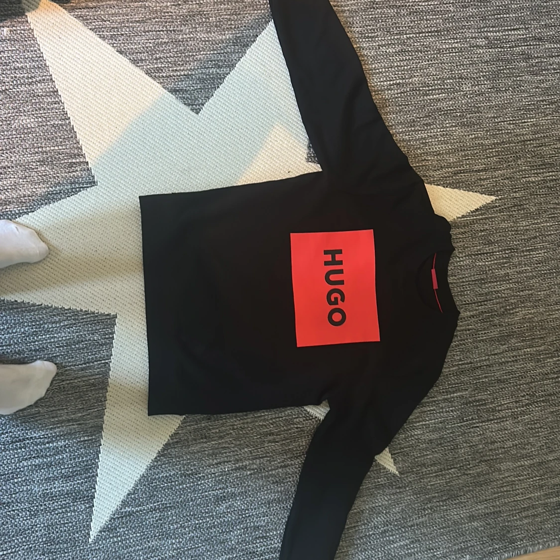 Svart tröja med röd HUGO-logga