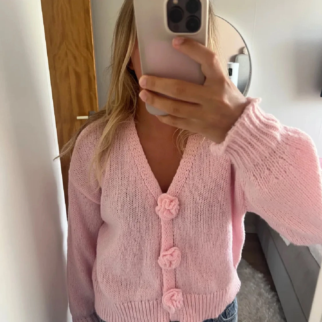 Ljusrosa kofta med blommiga knappar