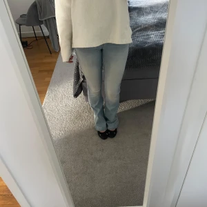 Ljusblå bootcut jeans - Säljer ett par ljusblå jeans med bootcut passform och klassisk femficksdesign. Jeansen har normal midja och är tillverkade i mjukt denimtyg som sitter snyggt över höfterna och låren. Perfekta för dig som gillar en avslappnad men ändå trendig look. Storlek XSx34