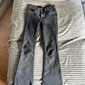 Svarta bootcut jeans från gina tricot - Snygga svartgråa jeans från ginatricot med medelhög midja med utsvänga ben. Har sprättat upp dom längst ner så dom blir längre. Säljer då dom inte kommer till användning längre! Storlek 34