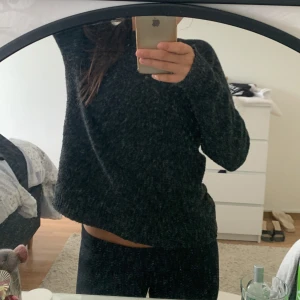 Mörkgrå stickad tröja - Mysig mörkgrå stickad tröja med enkel och stilren design. Tröjan har rund halsringning och långa ärmar, perfekt för kyliga dagar. Den är lite loose i passformen och passar dig som gillar en avslappnad look.