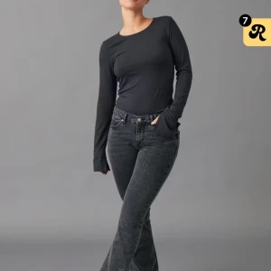 Mörkgrå bootcut jeans med låg midja - Snygga mörkgrå jeans med bootcut och låg midja. Jeansen har klassisk femficksdesign och är tillverkade i ett stretchigt denimtyg som sitter skönt. Perfekta för dig som gillar en trendig siluett med lite utsvängda ben.