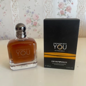 Emporio Armani Stronger With You Intensely - Parfymen Stronger With You Intensely från Emporio Armani, 100 ml, kommer i en stilren glasflaska med mörk bärnstensfärgad vätska och svart kork. Förpackningen är svart med orange detaljer och tydlig logga. En modern och maskulin doft.