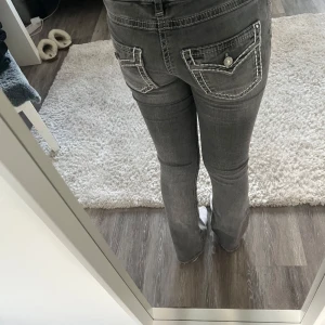 Grå jeans från Gina tricot  -  Grå jeans med vit broderi på fickorna, storlek 158. (Lika lång som de i storlek 164) Från Gina Tricot. Mycket fint skick, inga tecken på användning. Och är även Low waist.  