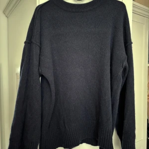 Mörkblå stickad tröja Arcane Attire - Enkel och stilren mörkblå stickad tröja från Arcane Attire i 100% Kashmir. Tröjan har rund halsringning, ribbade muddar och lång ärm. Superbra skick, knappt nopprig. Passar både S/M 