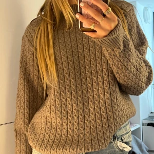 Beige stickad tröja (RIDNING)  - Den är från ett ridmärke, men jag har använt den i vardagen :)Säljer en beige stickad tröja från Equine i storlek L. Tröjan har ett klassiskt kabelstickat mönster, rund halsringning och långa ärmar. Perfekt för dig som gillar en avslappnad men ändå snygg stil. Supermjuk och passar till jeans eller kjol.