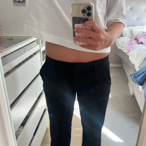 Low waist kostymbyxor - Snygga svarta kostymbyxor från Nelly i klassisk rak modell. Byxorna har hällor för bälte och stängs med dragkedja och knapp. Perfekta till en clean och stilren look, passar till både sneakers och boots.