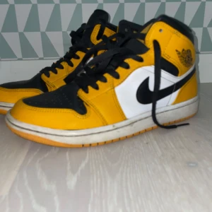 Nike Air Jordan 1 Mid svart/gul EUR 40 - Hej!! Säljer ett par snygga Jordan 1 mid taxi för ett bra pris, skorna är använda cirka 7 månader varsamt. Skorna har inga defekter men en liten gul fläck på sulan. Hör av dig vid minsta fundering!?