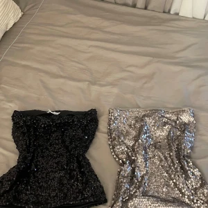 Paljett-tubtoppar svart & silver - Två glittriga kjolar som funkar som tubtoppar, en i svart och en i silver. Den silvriga kjolen är från Kappahl och den svarta kjolen är från size and needle. 