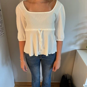 Vit blus med knyt och fyrkantig ringning - Supersöt vit blus med fyrkantig ringning och trekvartsärmar. Blusen är från lager 157. Jag säljer den pga att den inte kommer till användning tyvärr.❤️Pris kan diskuteras!!