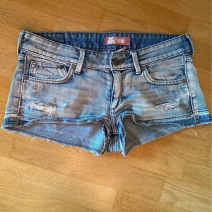 Lågmidjade jeansshorts med slitningar - Snygga lågmidjade jeansshorts från hm  i ljusblå denim med slitna detaljer och råa kanter. 
