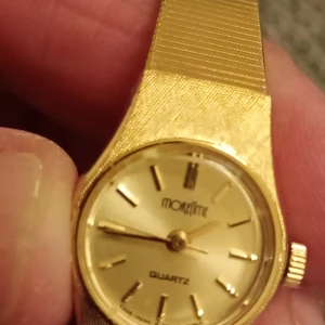 Guldfärgad Moretime quartzklocka - Stilren guldfärgad Moretime quartzklocka med klassisk rund urtavla och smalt armband. Klockan har en metallboett och baksida i rostfritt stål. Snygg och tidlös design som ger en lyxig känsla till din outfit. Nytt batteri behövs.