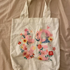 Vit/beige tygväska - Fin tygväska som är perfekt att ha till stranden med bikini och handduk. Superfint tryck som är somrigt 