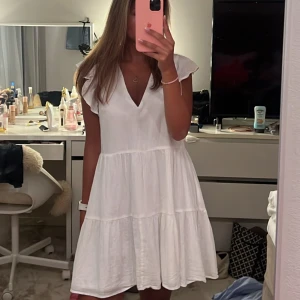 Vit somrig klänning med volang - Superfin vit klänning med v-ringning och volangärmar. Köpt från H&M i storlek S🤍