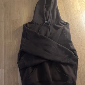 Brun hoodie från Bik Bok  - Mysig brun hoodie från Bik Bok i storlek S. Klassisk modell med huva, snörning och känguruficka framtill. Perfekt för chill dagar eller när du vill ha en enkel och stilren look. Tillverkad i mjuk bomullsblandning.