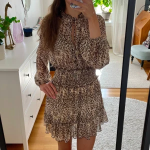 Leopardmönstrad Zara klänning - Superfin klänning från Zara med leopardmönster! Jätteskön! Klänningen har långärmade, luftiga ärmar, smockad midja och volangkant nertill. V-ringad med knytning vid halsen. Kontakta om du har frågor💕