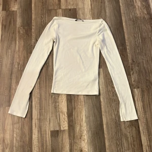 Vit långärmad topp från Gina Tricot - En stilren vit långärmad topp från Gina Tricot i storlek XS. Toppen har en rak, enkel passform och är tillverkad i mjukt material. Perfekt att styla med jeans eller kjol för en clean look. Jag tycker den är ganka lik intimissimi tröjan, den utan spets säljer för den ör för liten 💗💗