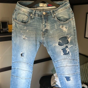 Ljusa jeans från 883 Police - Säljer ett par ljusa jeans från 883 Police med slitna detaljer och hål för en trendig look. Modellen heter Moriarty och har en slim passform. Perfekta för dig som gillar en avslappnad stil med edge.