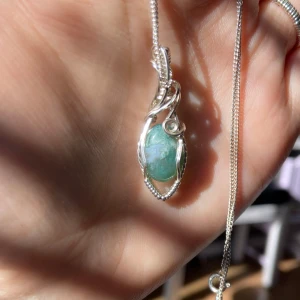 Halsband med turkos sten - Elegant berlock med en vacker turkos sten infattad i en detaljerad silverram. 