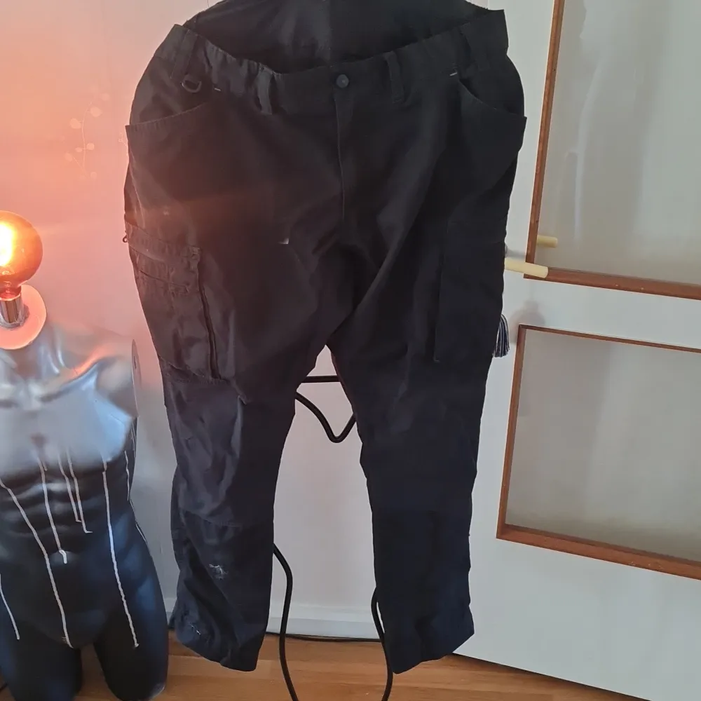 Säljer ett par svarta arbetsbyxor från Blåkläder. Byxorna har flera praktiska fickor och en robust design, perfekt för arbete. De är tillverkade i slitstarkt material och har en bekväm passform.. Farkut & Housut.
