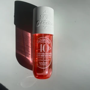 Doftmist från Sol de Janeiro - Fräsch doftmist från Sol de Janeiro med noter av brasiliansk plommon och vaniljträ. Flaskan är genomskinlig med en livlig röd färg och har en vit kork.  (Den är lite använd men fortfarande fräch)