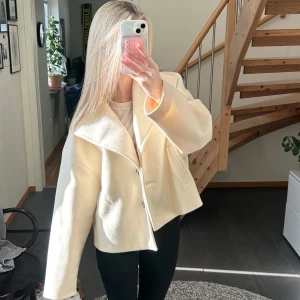Beige kappa med knappar - Säljer en ljus beige kappa med knappar✨Har en liten fläck på armen (se bild tre) men tycker inte att det är något man tänker på. Köpt på Vero Moda