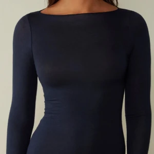 Mörkblå Intimissimi Tröja  - Säljer en stilren mörkblå långärmad topp från Intimissimi. Perfekt för en elegant och minimalistisk look. Toppen är tillverkad i ett mjukt och stretchigt material som formar sig efter kroppen. 