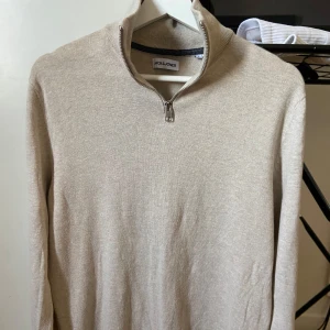 Halv zip Jack & Jones - Säljer en stilren beige halv zip från Jack & Jones. Perfekt för en avslappnad look. Passar riktigt bra under hela året 🔥 