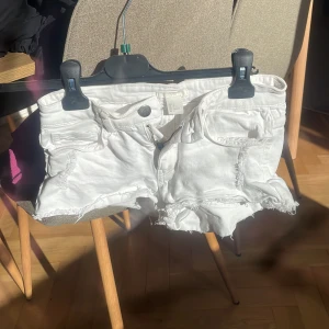 Vita jeansshorts från H&M - Säljer ett par vita jeansshorts från H&M med fransiga kanter och klassisk femficksdesign. Perfekta för varma sommardagar. 🩳✨