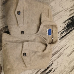 Beige overshirt från jack&jones - Säljer en stilren beige overshirt från Jack&jones. Jackan har knappar framtill och två bröstfickor med lock. Perfekt för lager-på-lager-stil under höst och vår. Knappt använd