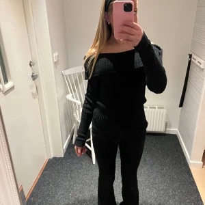 Svart ribbad offshoulder tröja - Snygg svart ribbad tröja med offshoulder-design. Tröjan har långa ärmar och en bekväm passform. Mycket bra skick. Det är bara att fråga om du undrar något eller vill ha fler bilder🩷
