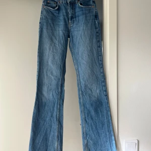 Blå bootcut jeans - Snygga blå bootcut jeans med hög midja. Perfekta för en avslappnad stil. Klassisk design med fem fickor och dragkedja.