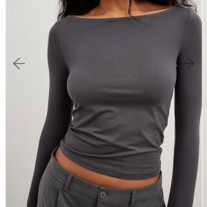 Mörkgrå långärmad topp - Snygg mörkgrå långärmad topp med en tight passform. Perfekt för en stilren look. Tillverkad i ett mjukt och bekvämt material.