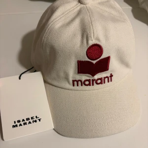 Keps från Isabel Marant - Vit keps från Isabel Marant med röd broderad logotyp framtill. Helt ny och aldrig använd så inga defekter. Pris kan diskuteras.