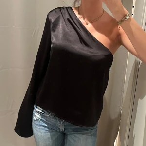 Oneshoulder topp Gina Tricot  - Snygg svart oneshoulder topp från Gina Tricot i storlek 36🥰 använd någon enstaka gång så jättebra skick!