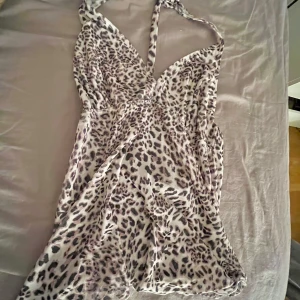 Leopardmönstrad klänning - Snygg leopardmönstrad topp med halterneck-design.toppen har en omlottstil som ger en smickrande passform.🎀