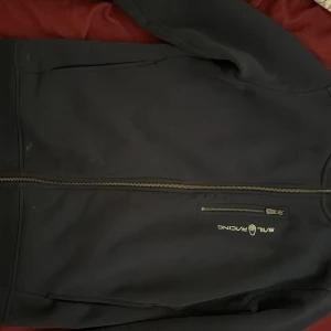 Svart jacka från Sail Racing - Säljer en svart jacka från Sail Racing med dragkedja och en bröstficka. Jackan har långa ärmar och en stilren design. Perfekt för en sportig look.175-183