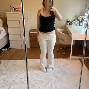 Vita stickade byxor från Nelly - Snygga vita stickade byxor från Nelly i storlek S. Byxorna har en hög midja och en bekväm, loose passform. Perfekta för en avslappnad stil med en ribbad detalj vid midjan.