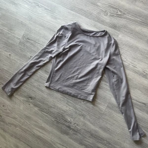 Grå croppad långärmad  - En grå croppad långärmad som är i super mjukt figurnära tyg 
