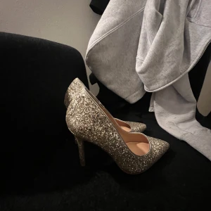 Glittriga guldiga pumps - Snygga glittriga pumps i guld med spetsig tå och hög klack. Perfekta för att lysa upp vilken outfit som helst. Storlek 38 ifrån märket Even&Odd köpta från Zalando för ett tag sen.   Endast använt en gång så de är i helt nytt skick! Priset kan diskuteras och har ni funderingar är det bara att höra av er!
