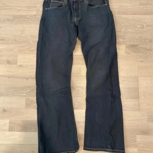 Mörkblå jeans från Lee - Snygga mörkblå jeans från Lee med klassisk femficksdesign och kontrastsömmar. Perfekta för en avslappnad stil. De har en rak passform med bootcut och normal midja.