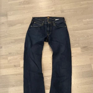 Mörkblå jeansbyxor - Snygga mörkblå jeansbyxor med klassisk femficksdesign och kontrastsömmar. Perfekta för en avslappnad stil. De har en normal passform med bootcut 