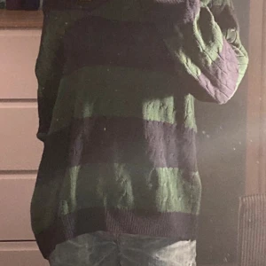 Striped off shoulder sweater  - Säljer en mysig stickad tröja med breda ränder i grönt och blått. Tröjan har en avslappnad passform och långa ärmar, perfekt för kyligare dagar. Den har en klassisk design med ribbade muddar vid ärmslut och nederkant.