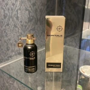 Montale Arabians Tonka Eau de Parfum - Elegant parfym från Montale i en stilren svart flaska med gulddetaljer. Doften Arabians Tonka kommer i en 50 ml flaska och levereras i en lyxig guldig förpackning. Perfekt för den som söker en unik och sofistikerad doftupplevelse.