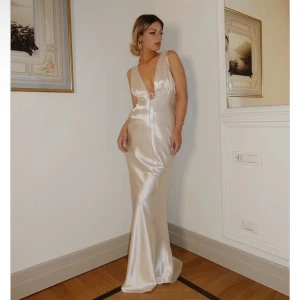 Balklänning - Champagnefärgad långklänning i siden med djup v-ringning och öppen rygg. Perfekt för bal. Aldrig använd 💗